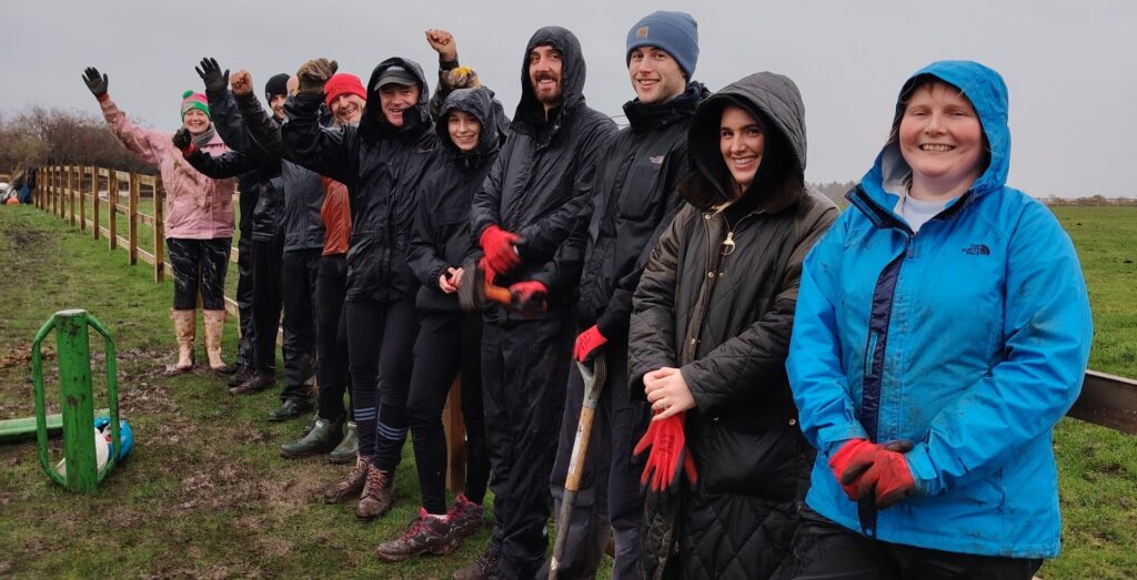 Line of volunteers outside in the rain
